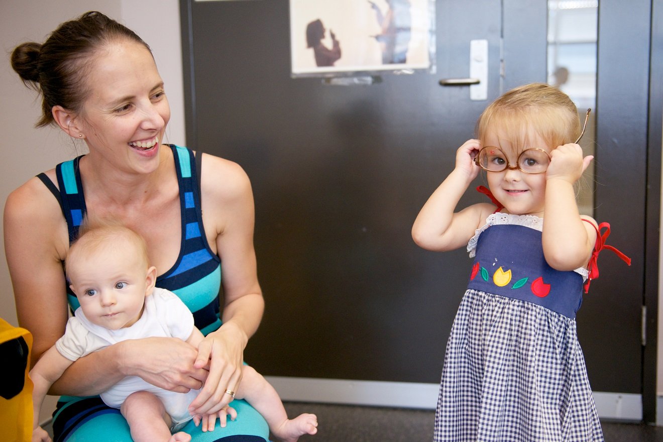 Child practicing dressing skills by putting on parent's glasses