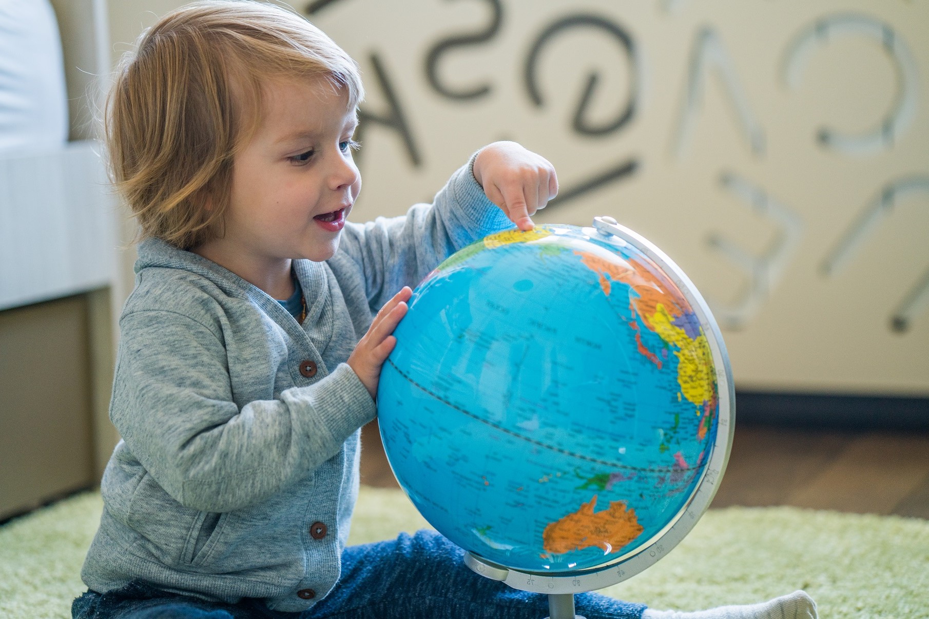 Child pointing at globe