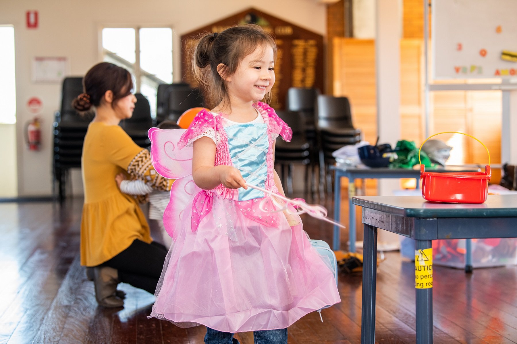 Child engaging in imaginative play, dressed up as a pink fairy.